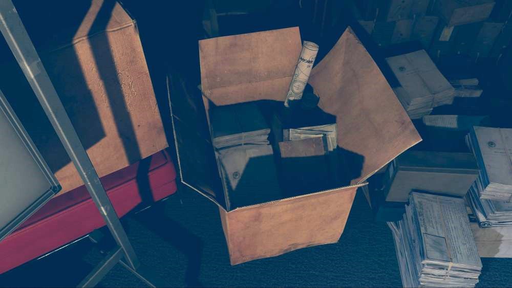 A cardboard box containing books and rolled documents